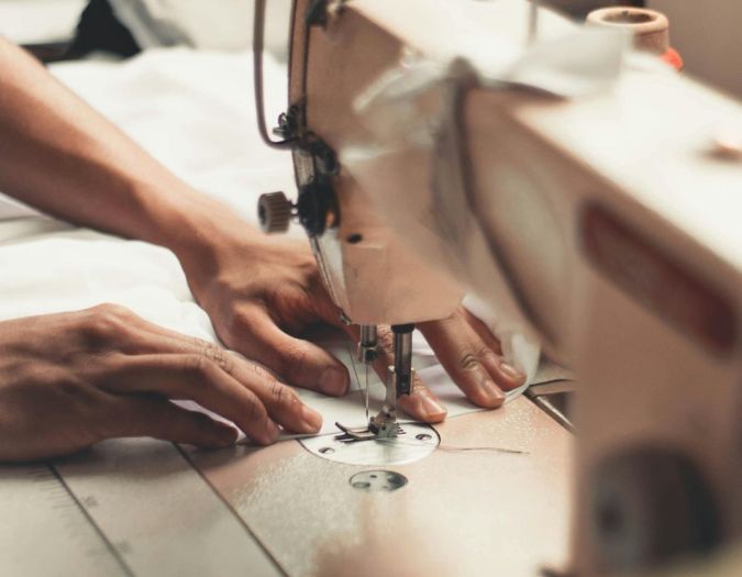 Expert hands creating garments with a sewing machine, symbolizing our quality